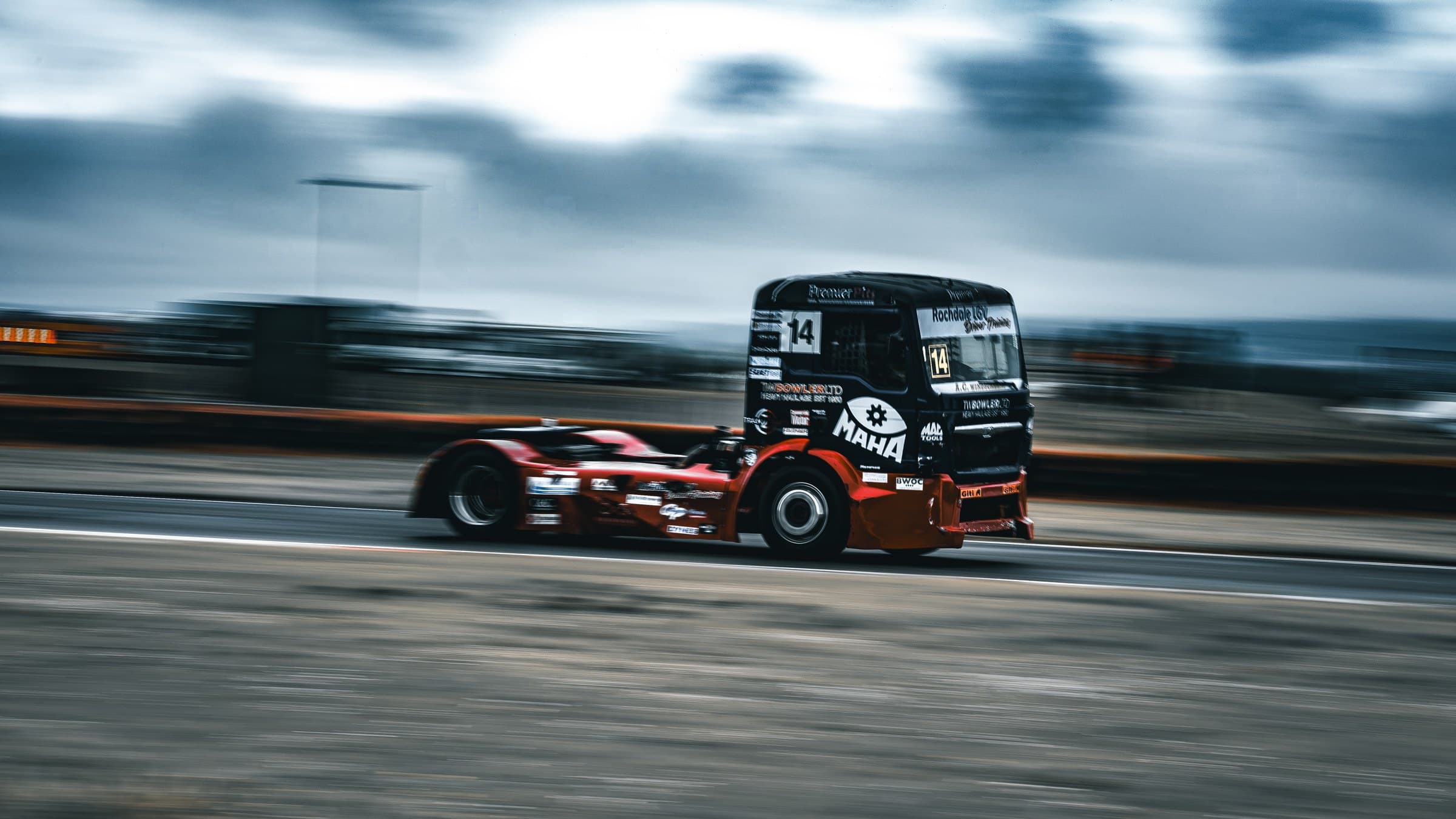 Diana, the number 14 truck, panned at speed under a stormy sky, the background streaked by motion blur