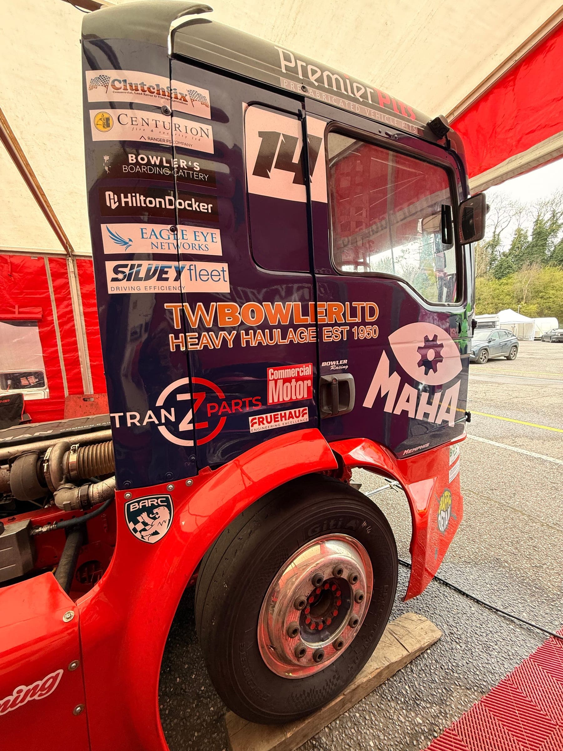 Low three-quarter view of Diana’s cab under the awning showing her partner decals